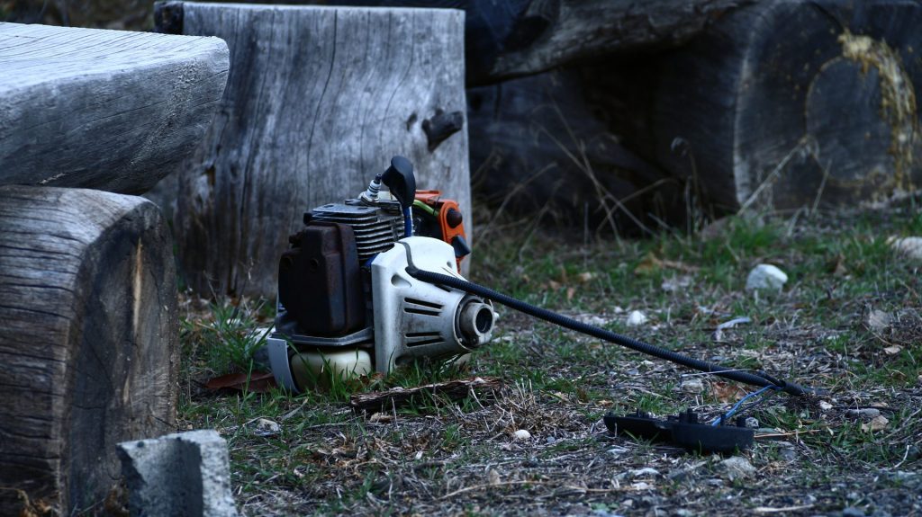 A broken chainsaw lies on the ground.